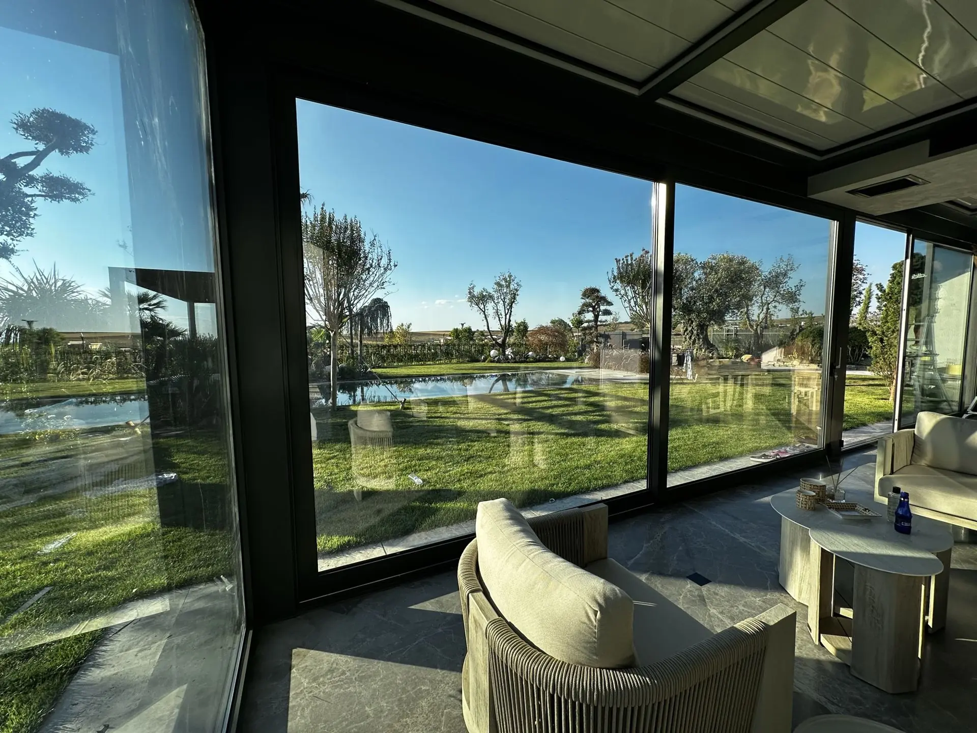 Bahçeye bakan cam cepheli pergola